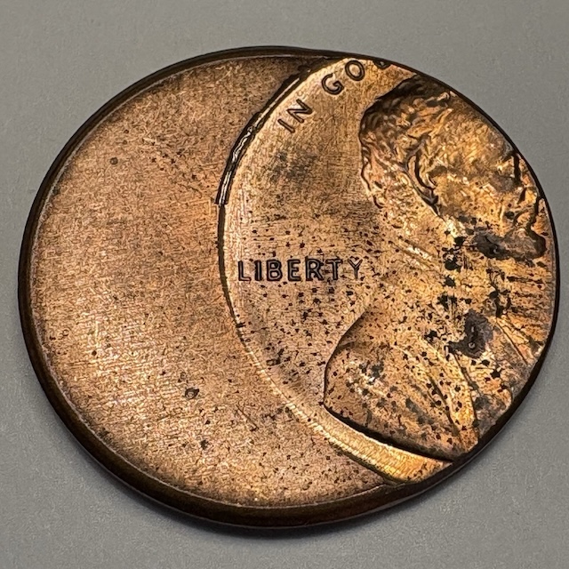 2004 penny broadstrike error coin showing expanded diameter and missing rim compared to normal cent